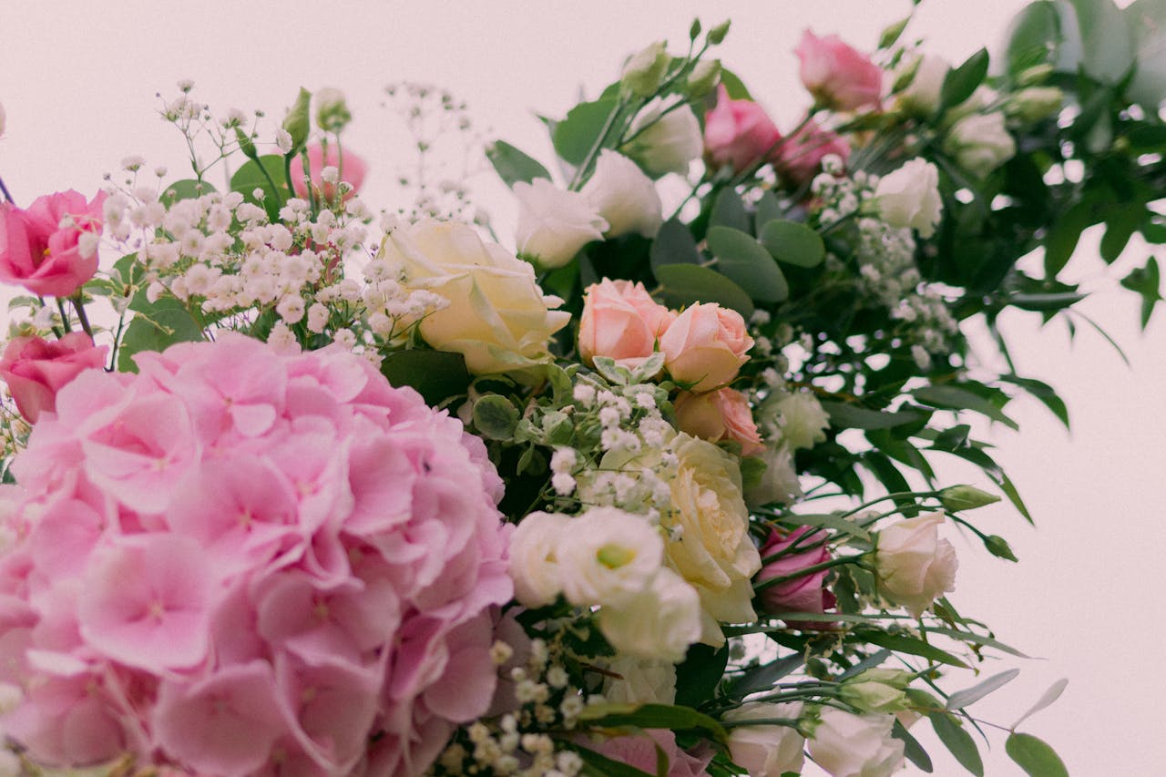 about-01 Beautiful floral bouquet featuring hydrangeas, roses, and greenery in soft pastel shades.